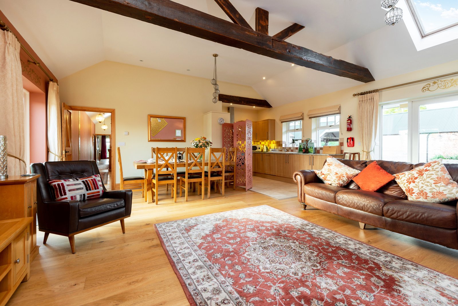 Spacious living room with wooden beams and cosy decor.