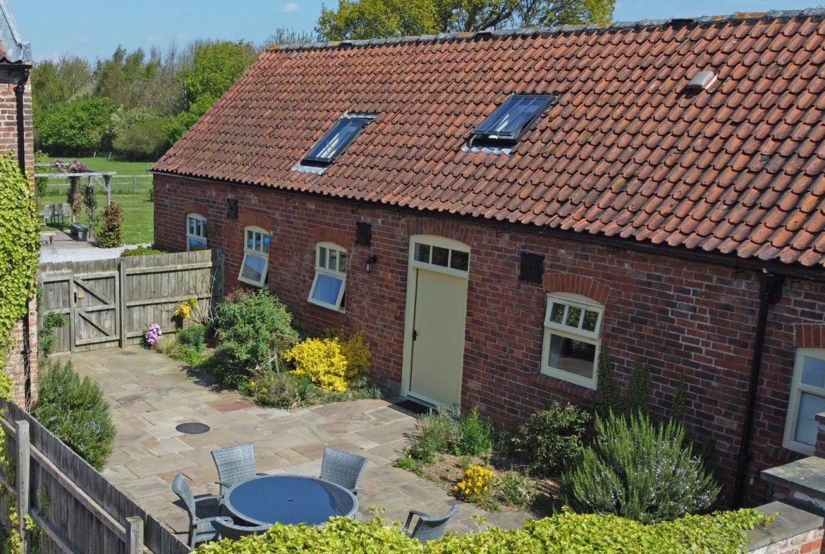 Charming brick cottage with garden on sunny day.
