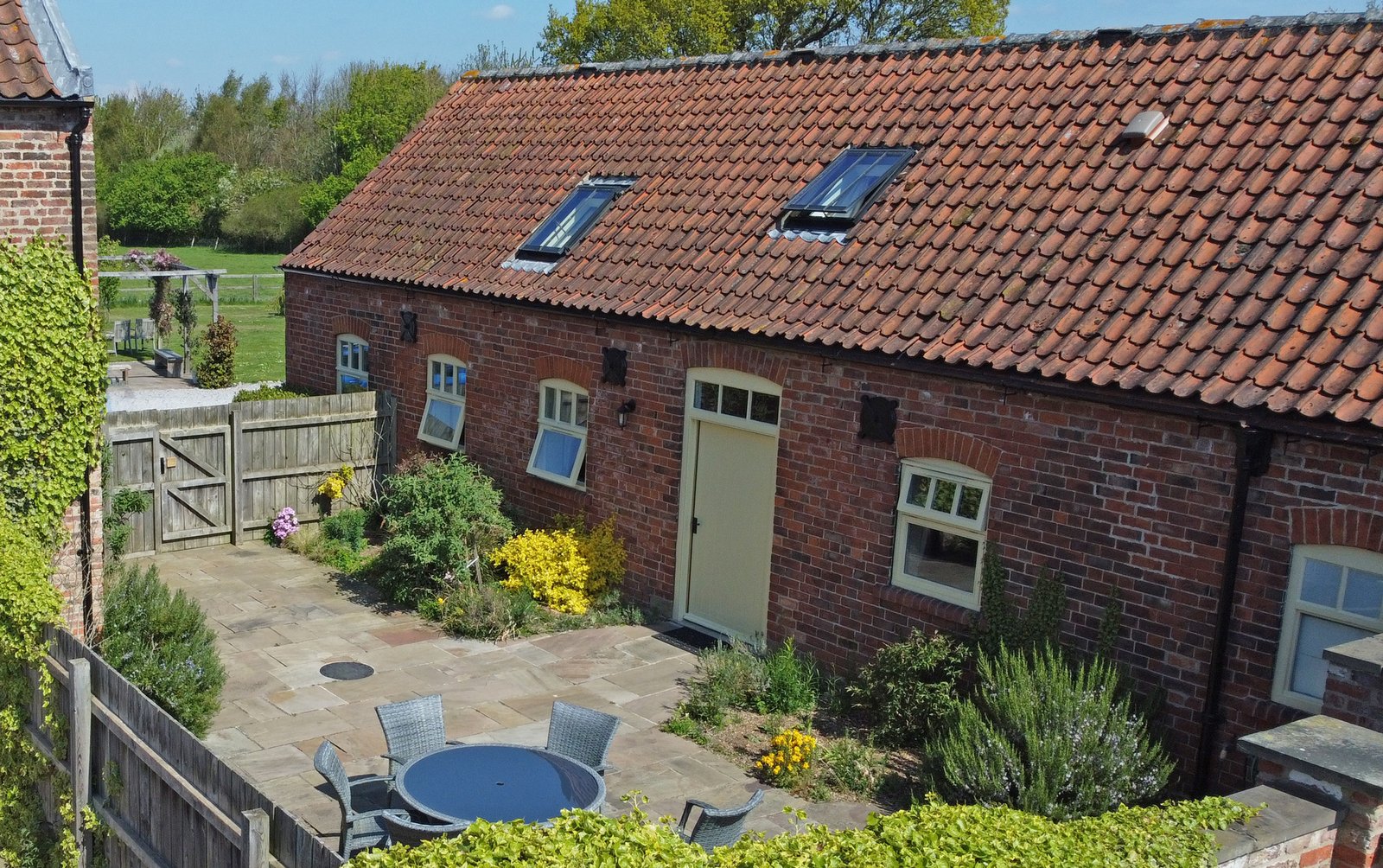 Charming brick cottage with garden on sunny day.