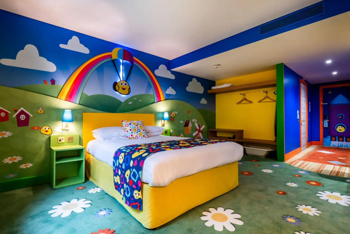 Colourful children's bedroom with rainbow theme and toys.
