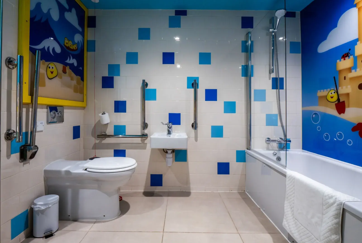 Bright bathroom with blue tile accents and bathtub.