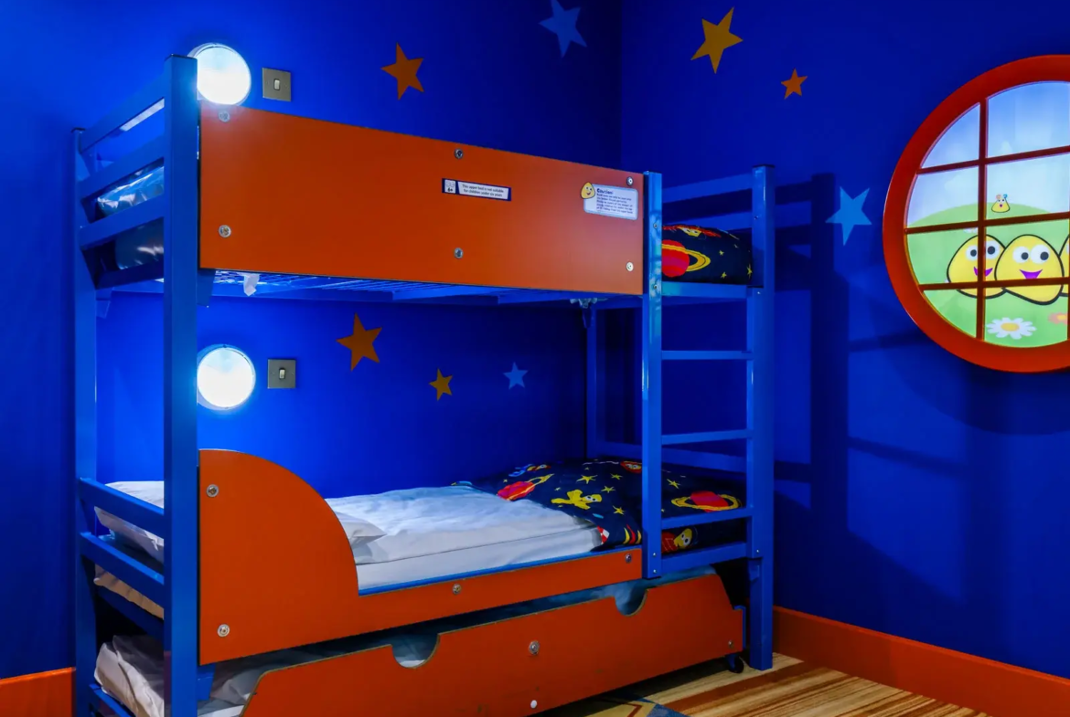 Children's room with blue starry decor and bunk bed.
