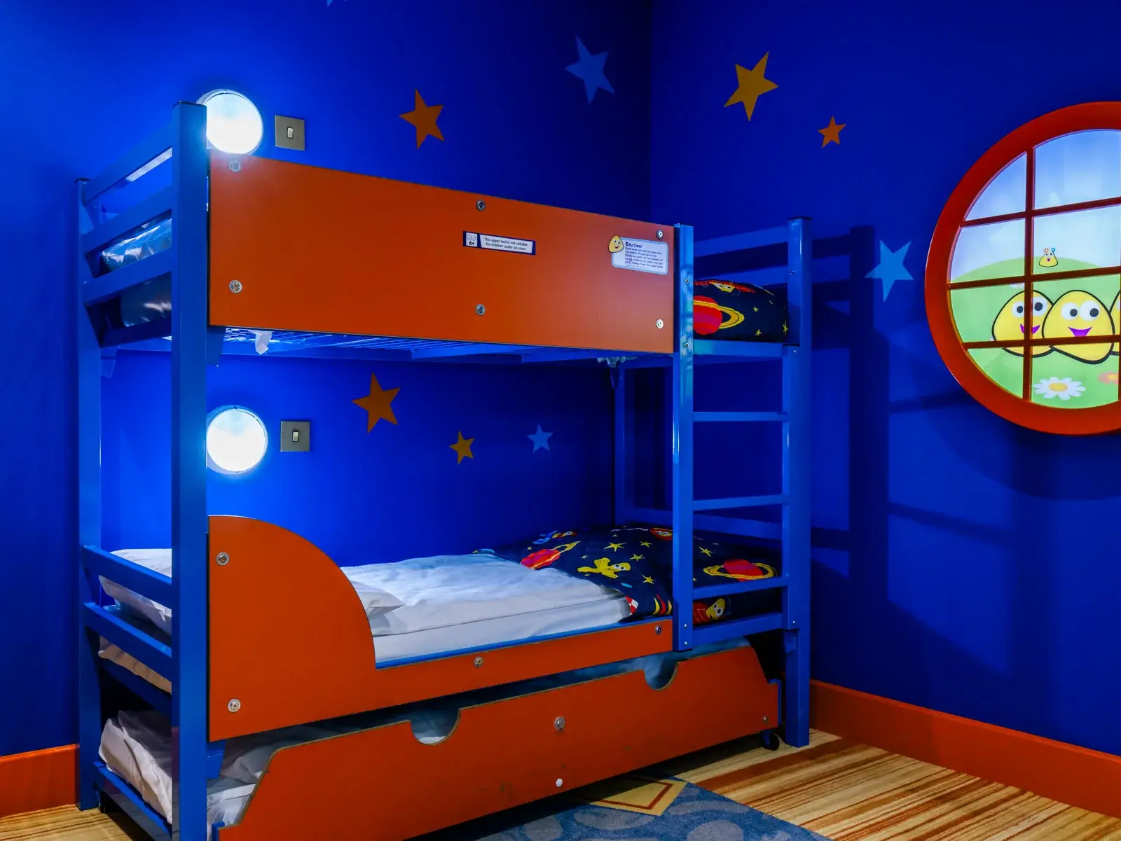 Children's room with blue starry decor and bunk bed.