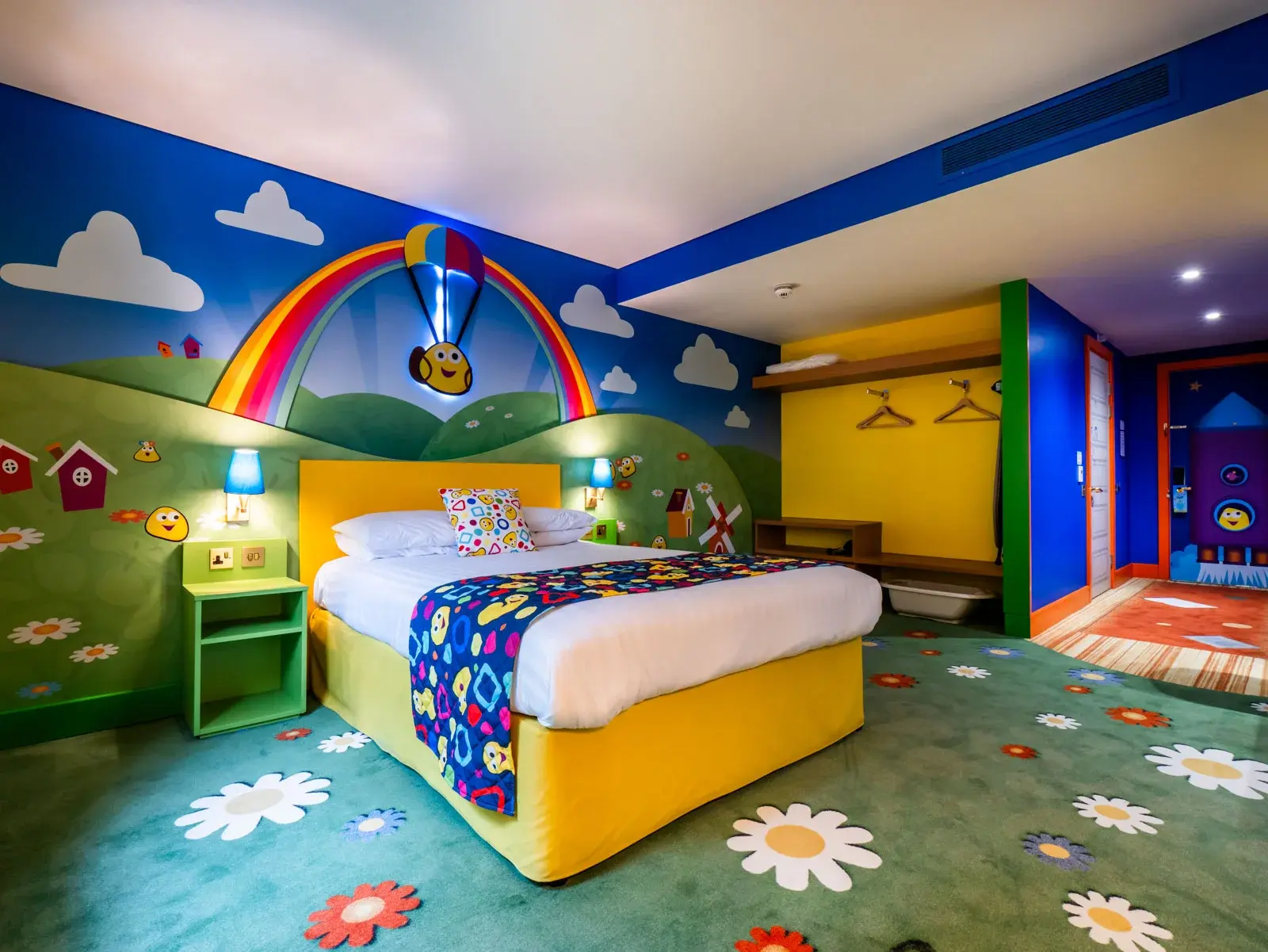 Colourful children's bedroom with rainbow theme and toys.