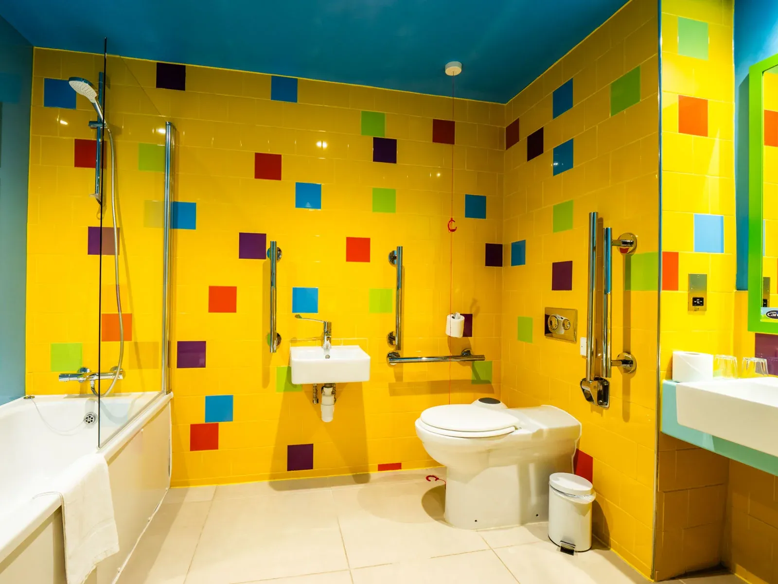 Accessible bathroom with vibrant colourful tiles.