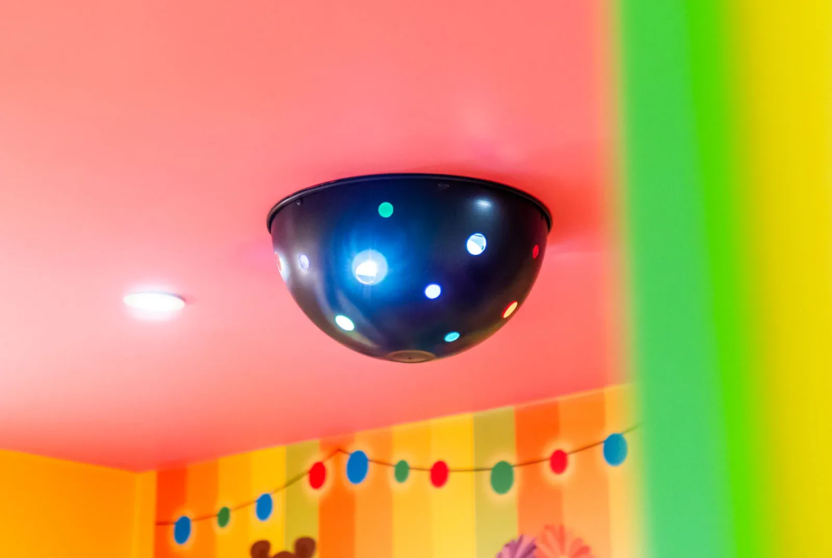 Colourful children's room with light fixture on ceiling.