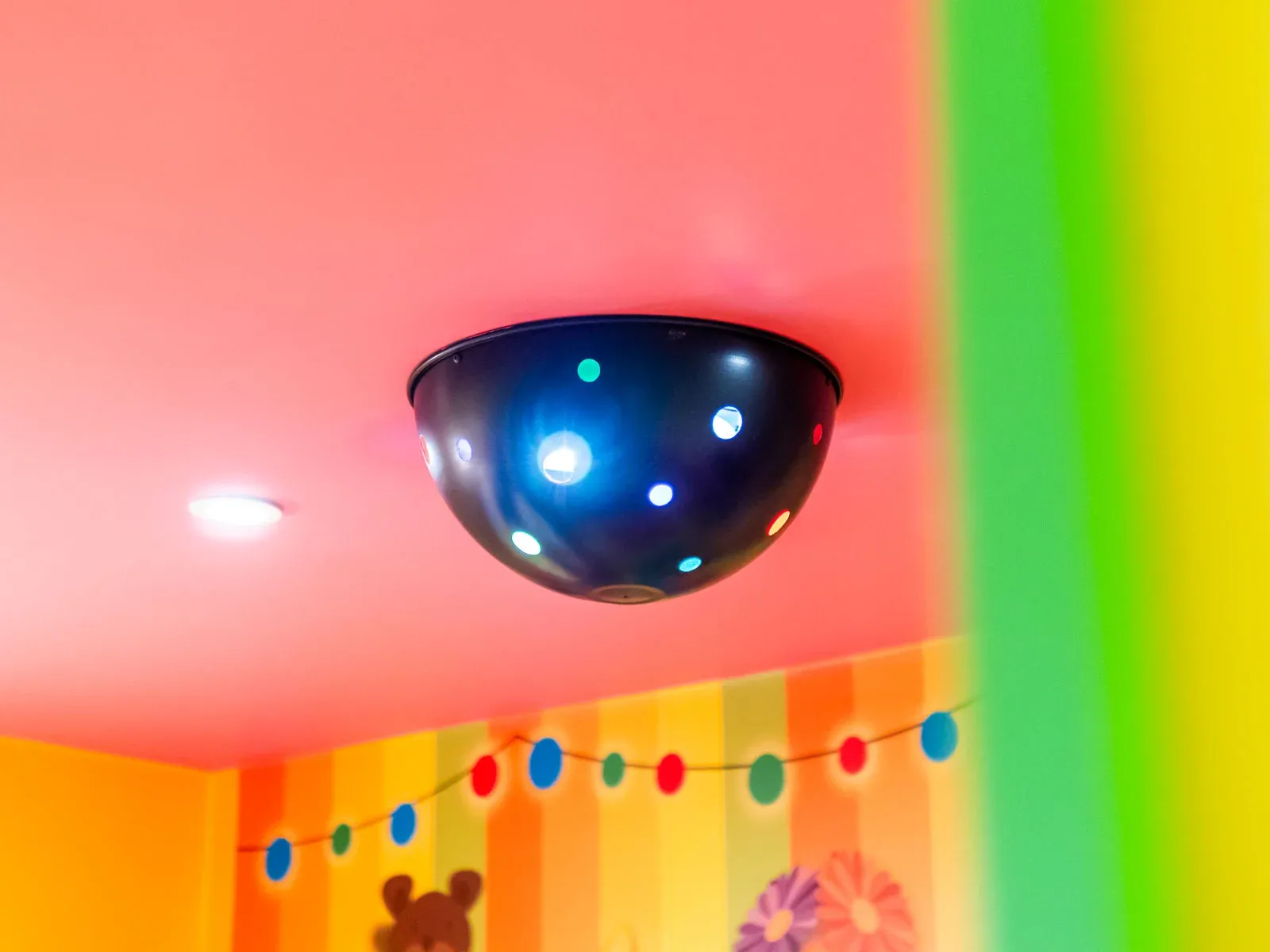 Colourful children's room with light fixture on ceiling.