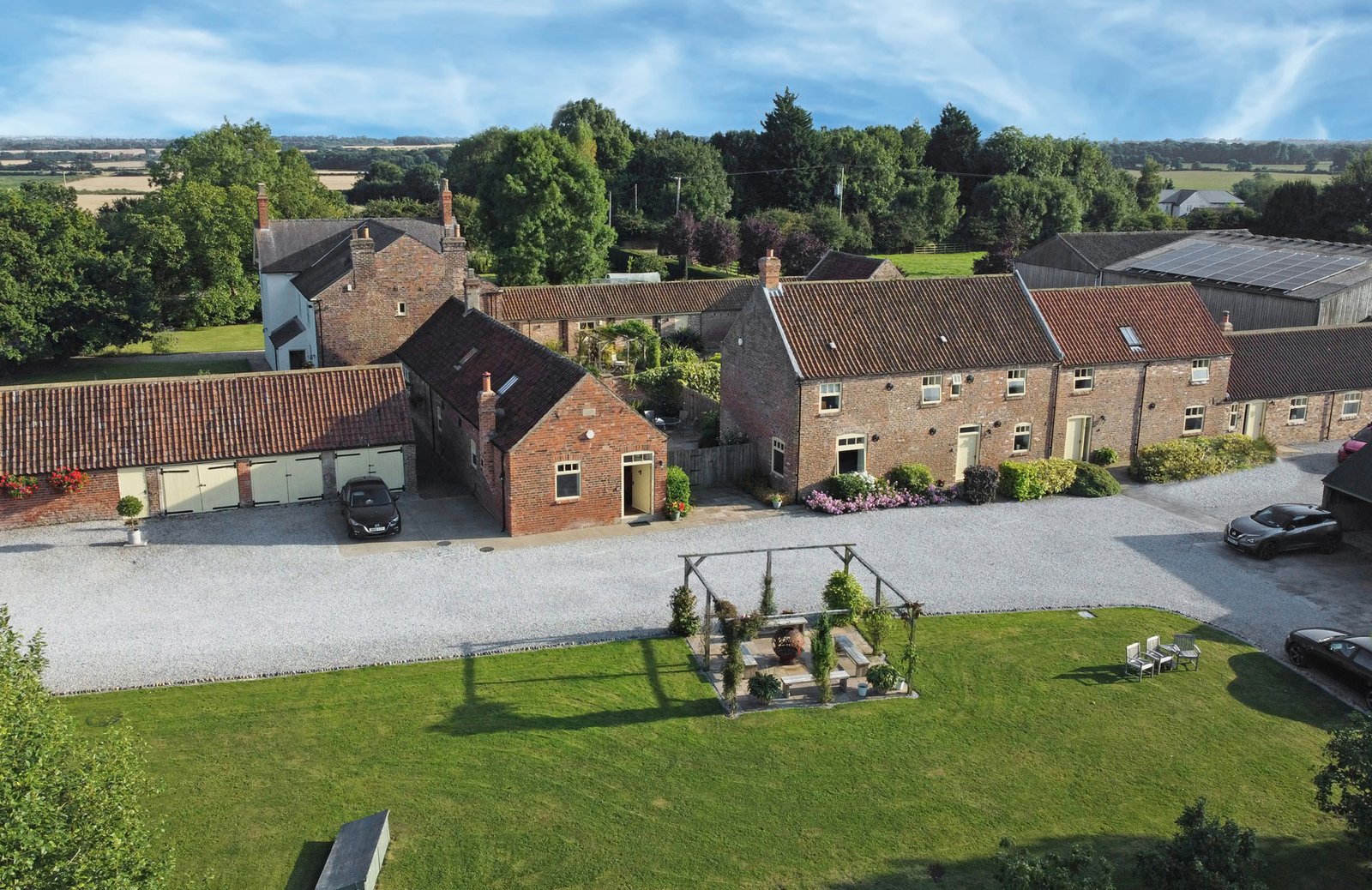 Aerial view of countryside brick cottages and gardens.