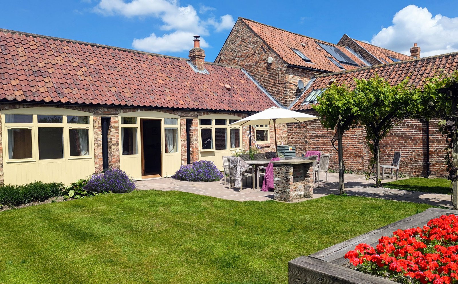 Charming cottage courtyard with garden and patio furniture.