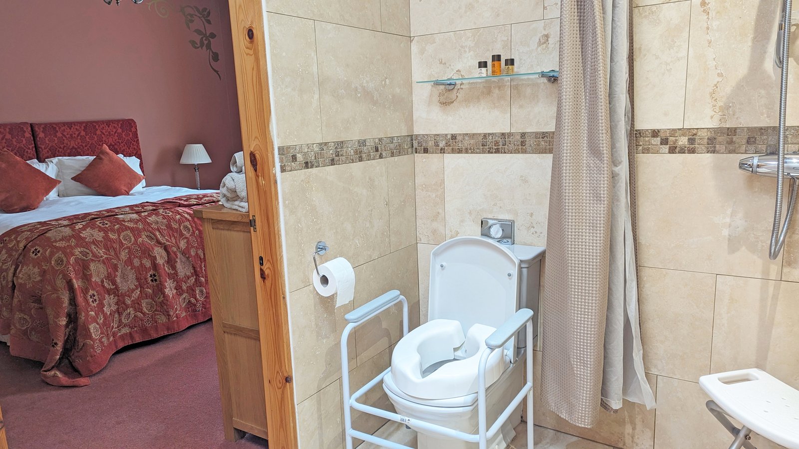 Accessible ensuite bathroom with grab bars and shower seat.