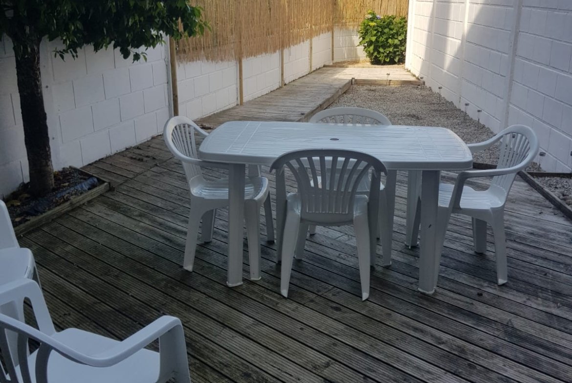 Outdoor seating on a wooden deck with chairs.