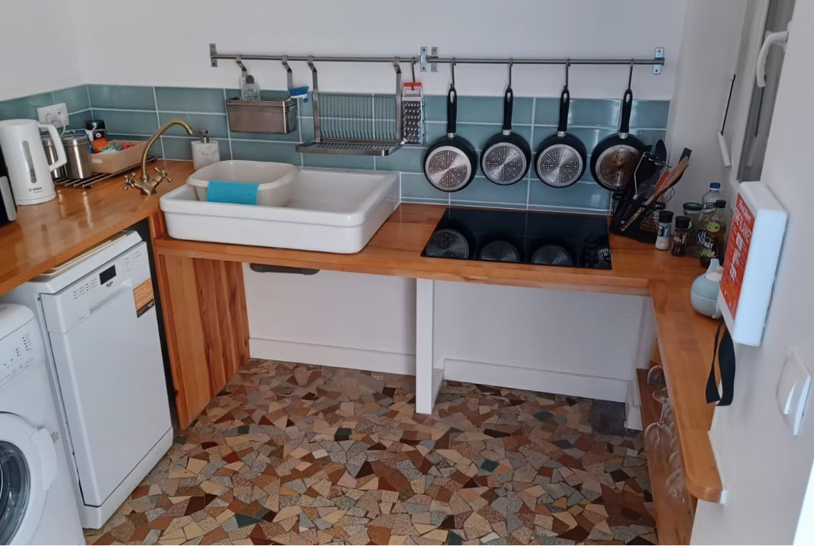Compact kitchen with modern appliances and tiled floor.