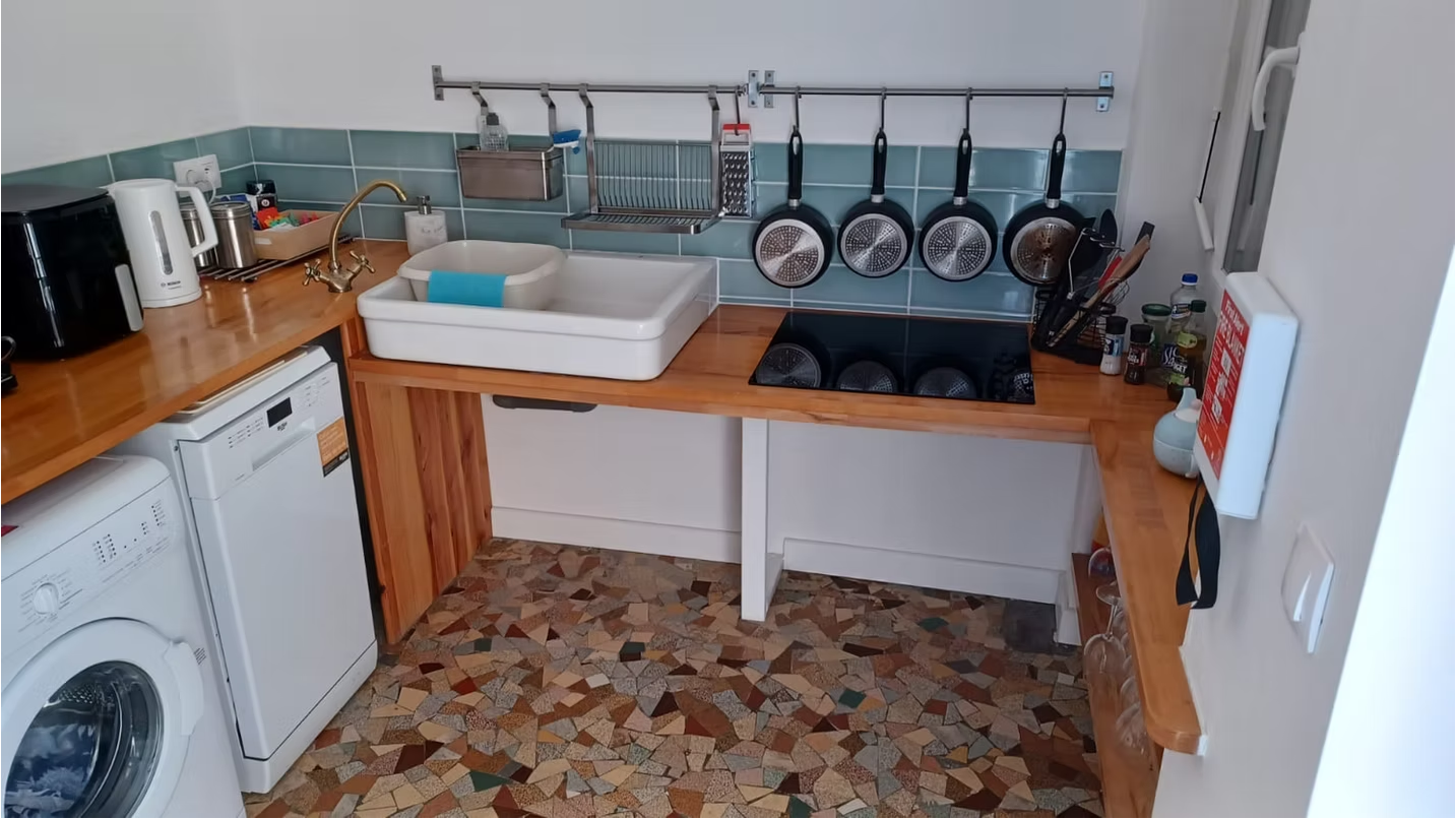 Compact kitchen with modern appliances and tiled floor.