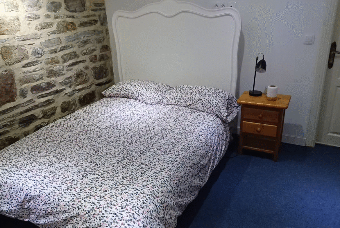 Cosy bedroom with stone wall and bedside table