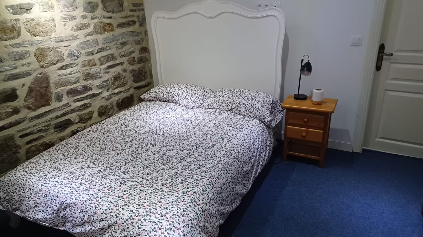 Cosy bedroom with stone wall and bedside table