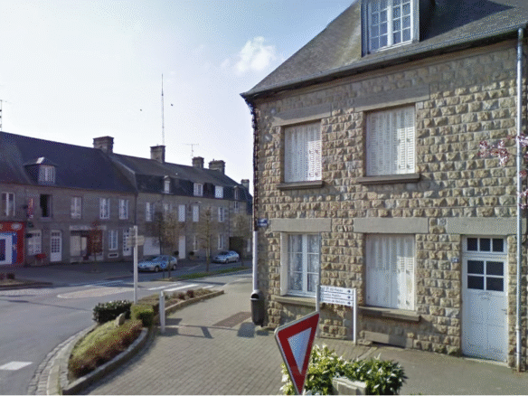 Stone buildings at a quiet village street corner.