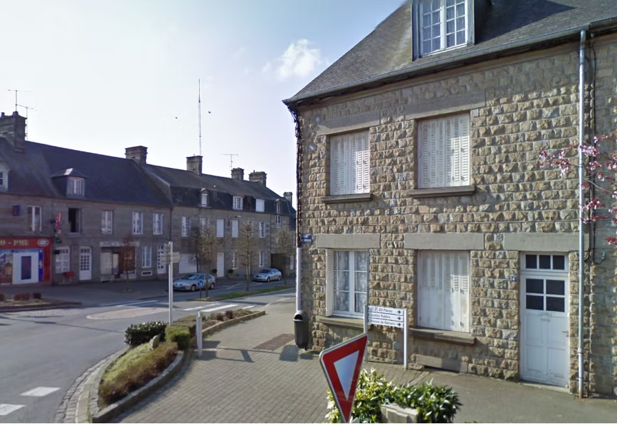Stone buildings at a quiet village street corner.