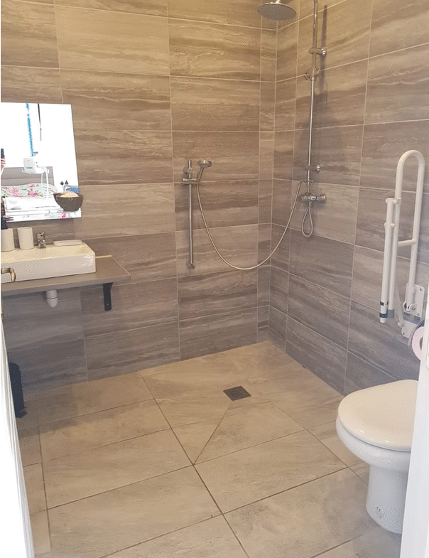 Accessible bathroom with shower, sink, toilet.