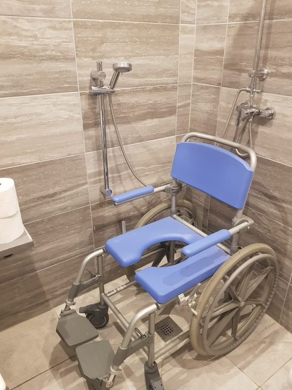 Accessible bathroom with blue shower wheelchair.