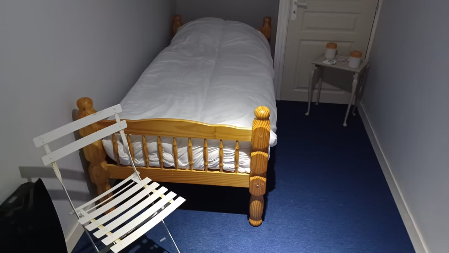 Small bedroom with single bed and chair