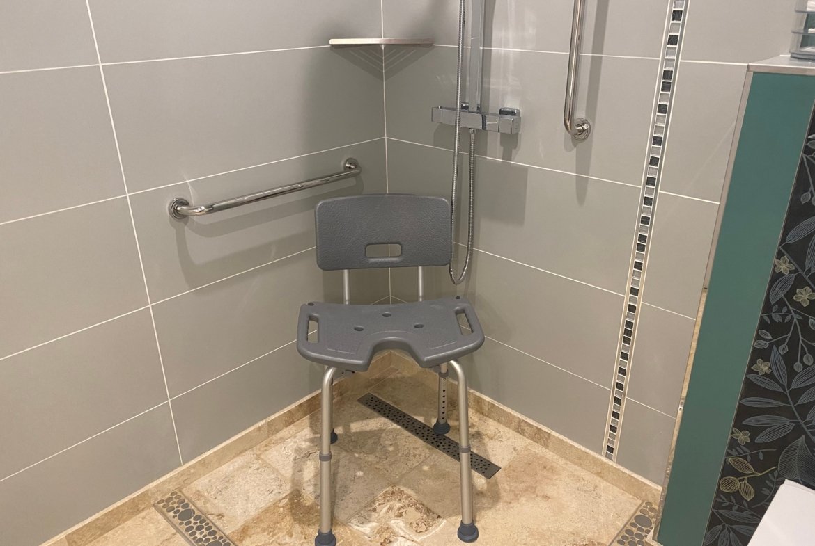 Accessible shower with chair and grab bars