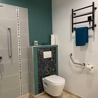 Modern bathroom with accessibility features and towel rail.