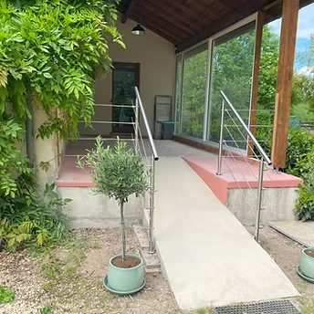Accessible ramp with railings near greenery.