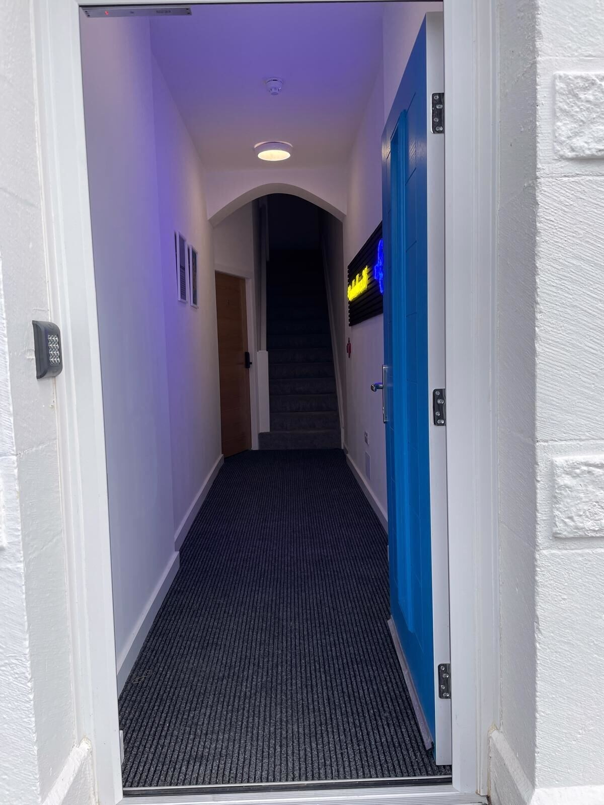 Open door revealing a hallway with stairs inside.
