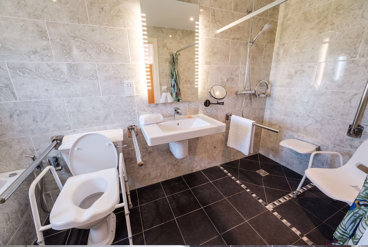 Accessible bathroom with grab bars and shower seat.
