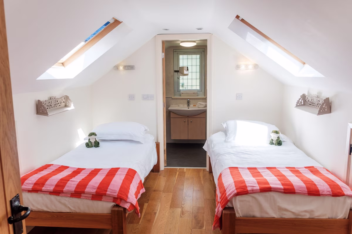 Attic bedroom with twin beds and bathroom door