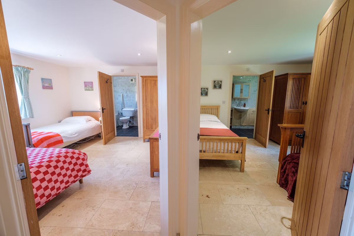 Two bedrooms with ensuite bathrooms and wooden furniture