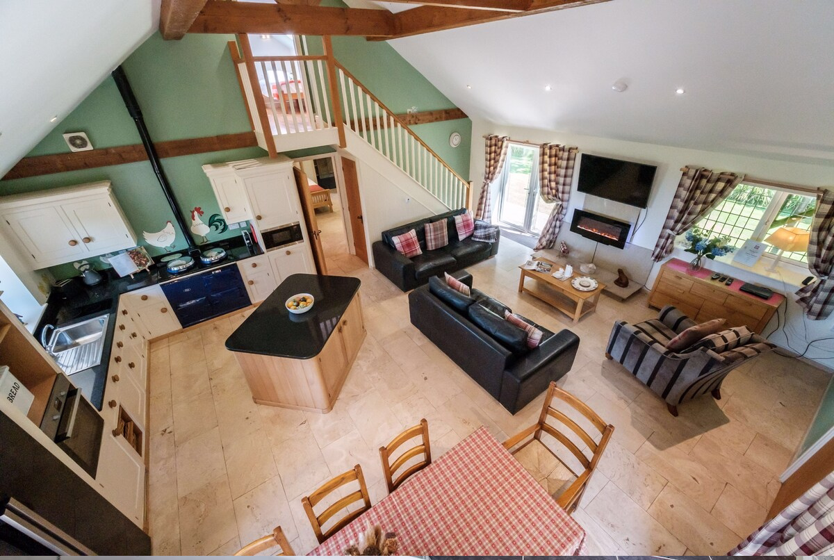 Spacious open-plan kitchen and living room with fireplace.