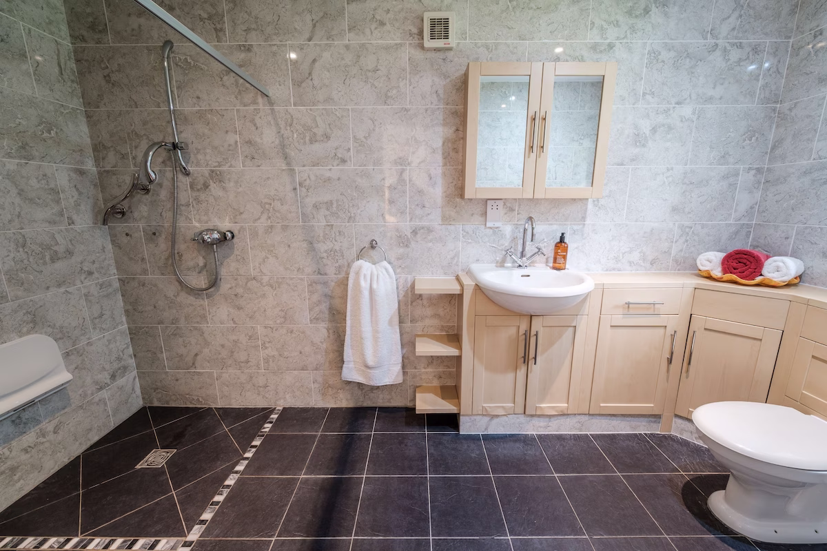 Modern bathroom with shower, sink, and toilet.