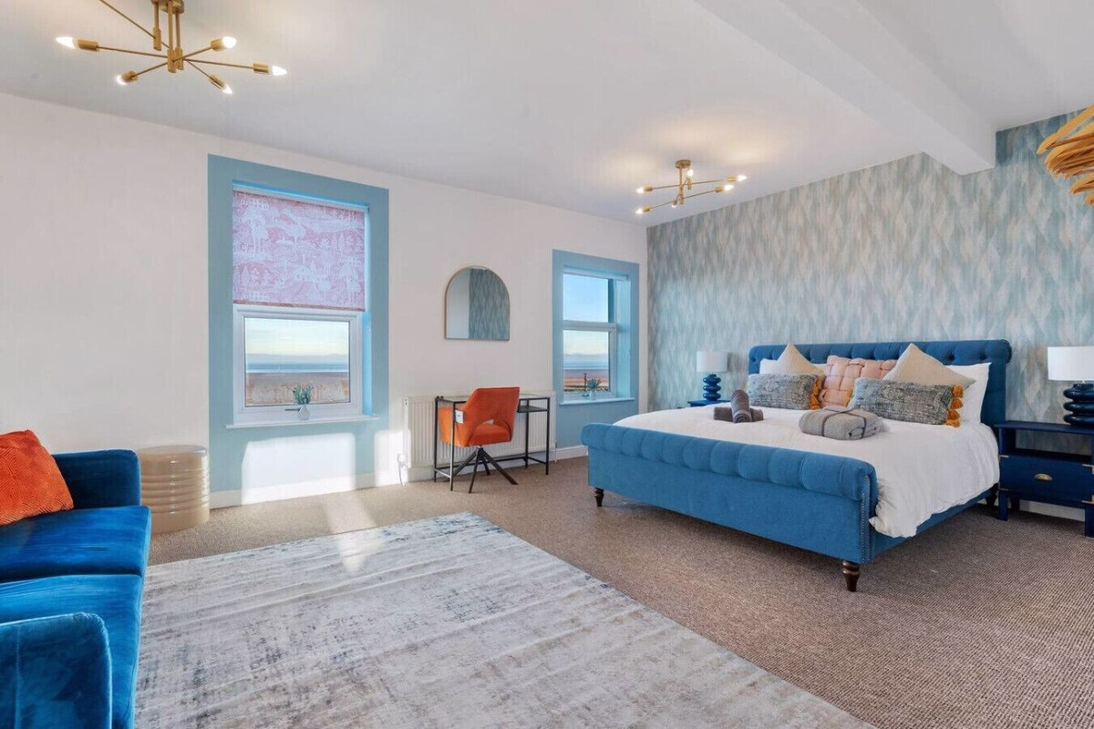 Stylish bedroom with blue accents and sea view.