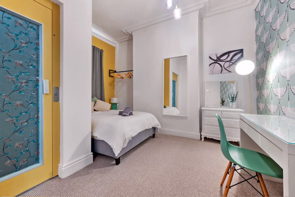 Cosy bedroom with modern decor and colourful accents.