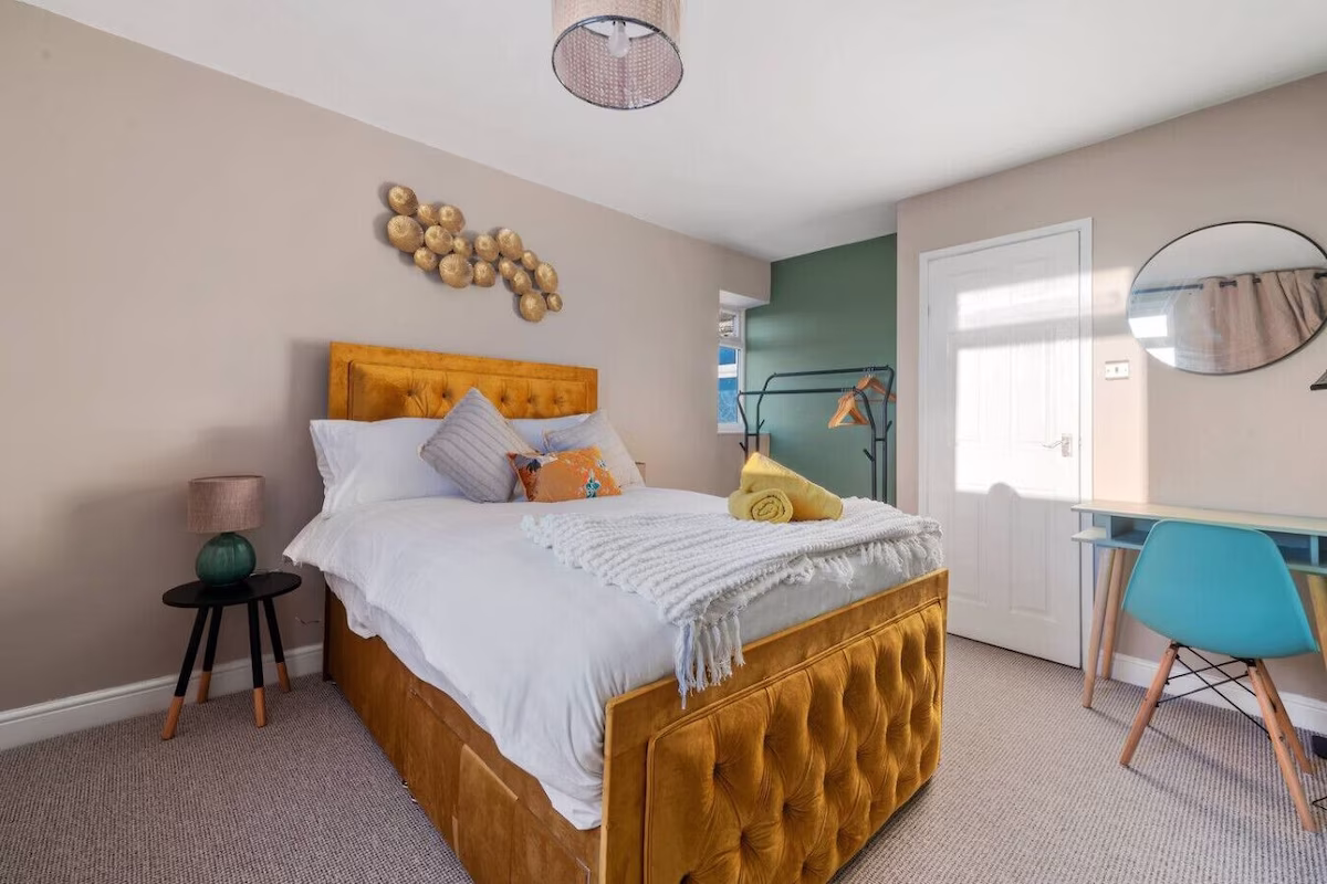 Cosy bedroom with orange bed and modern decor.