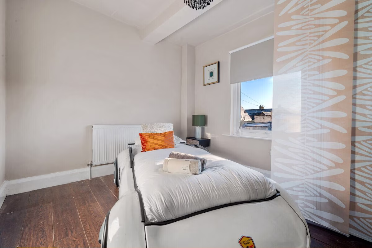 Cosy bedroom with single bed and window view.