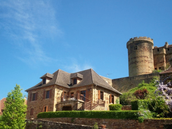 Historic stone house with tower and blue sky