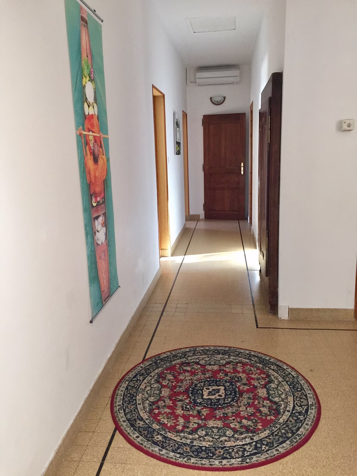 Hallway with artwork and round rug