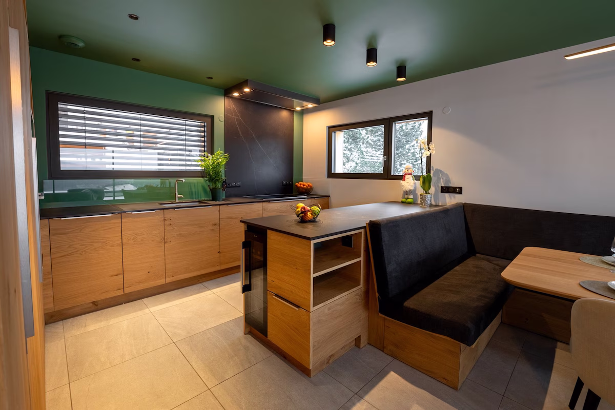 Modern kitchen with green accents and wooden cabinets.