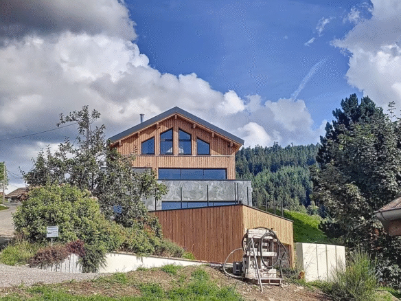 Modern wooden house with large windows amidst nature