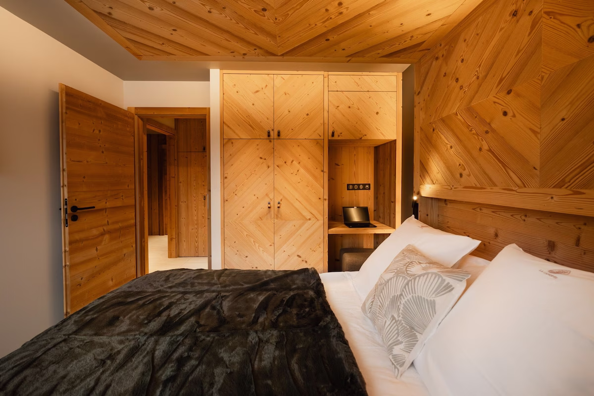 Cosy wooden bedroom with laptop desk.
