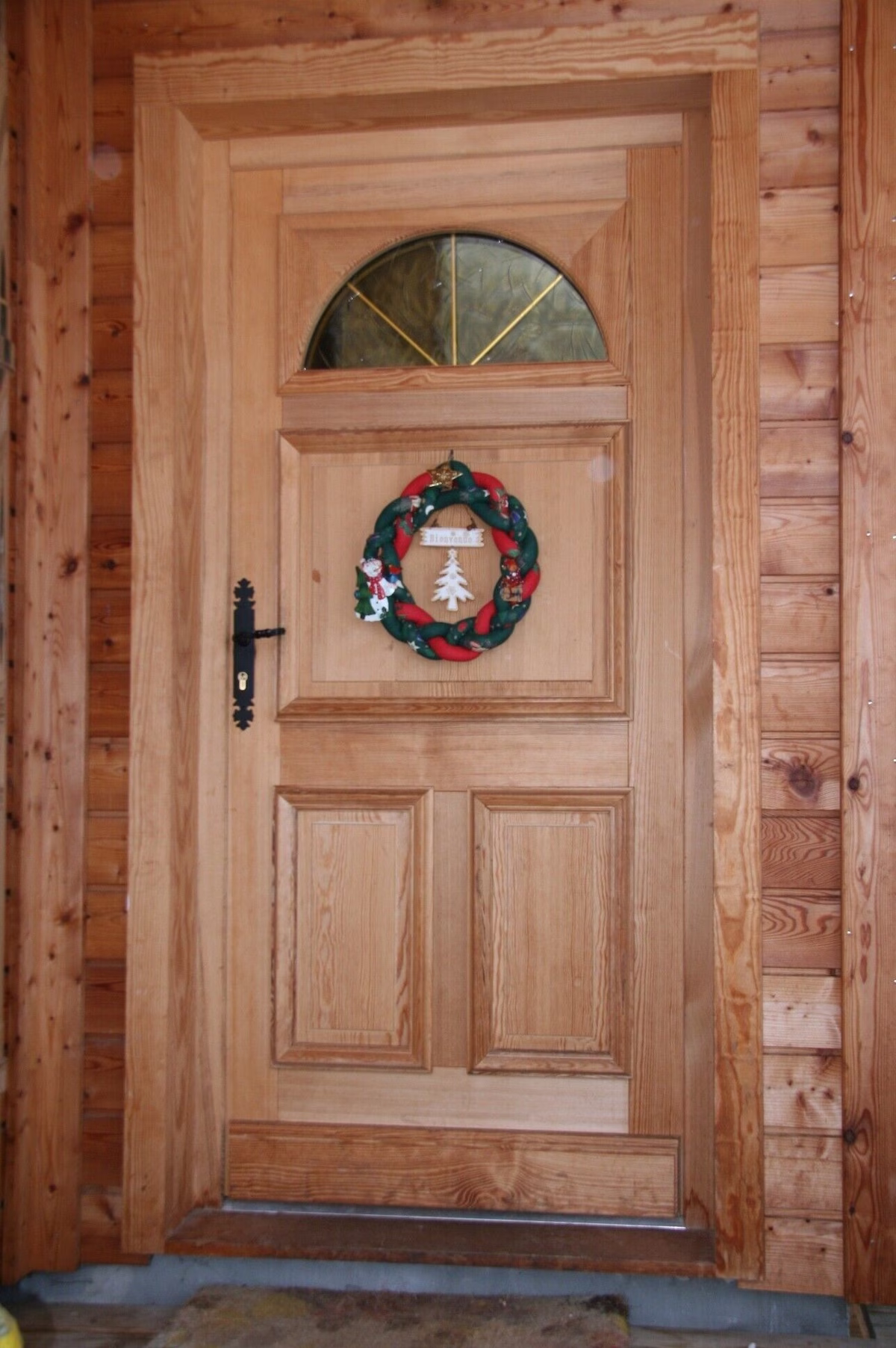 Wooden door with Christmas wreath decoration.