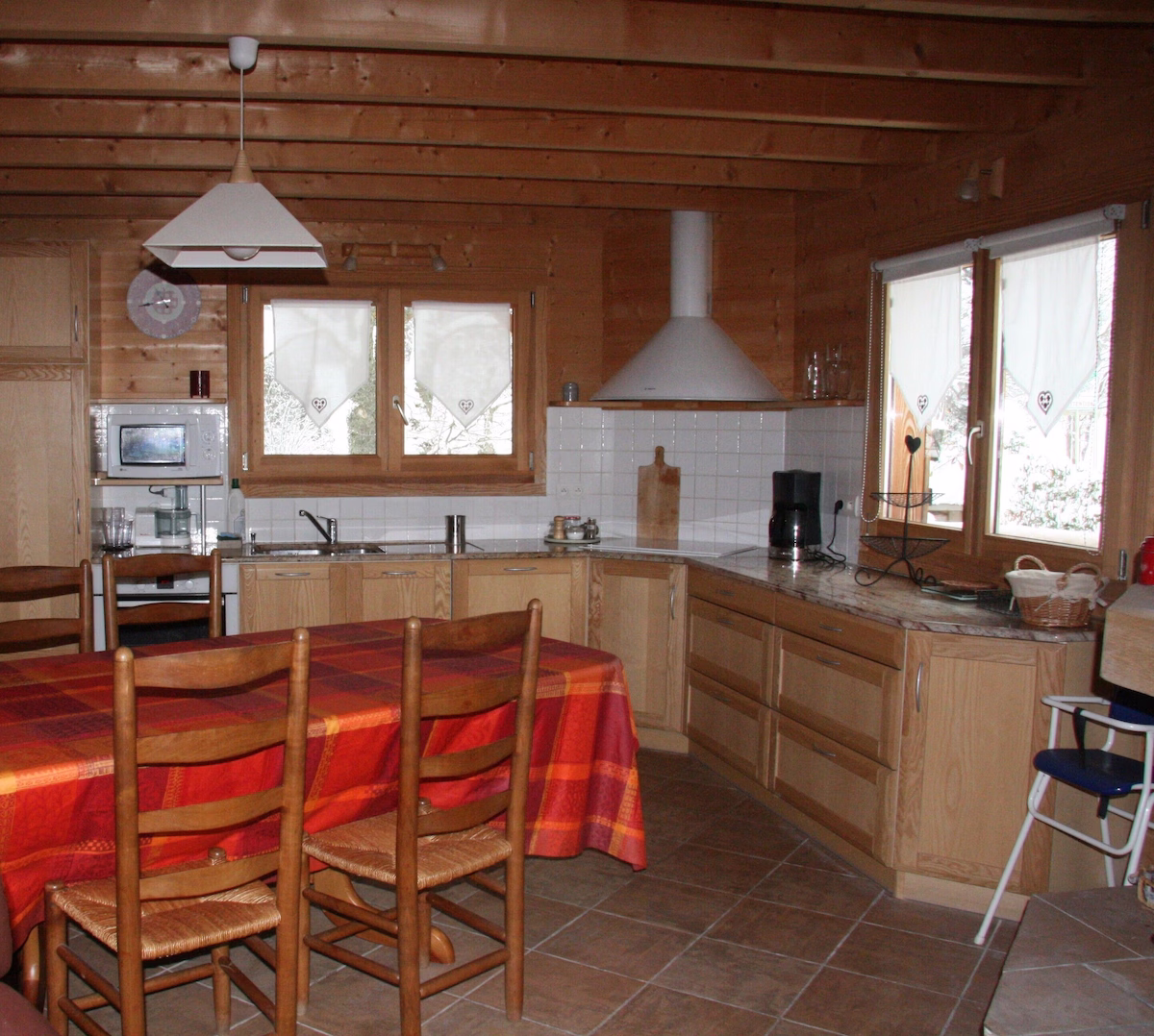 Rustic wooden kitchen with red tablecloth.