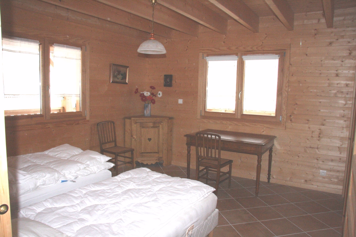 Cosy wooden bedroom with two single beds.