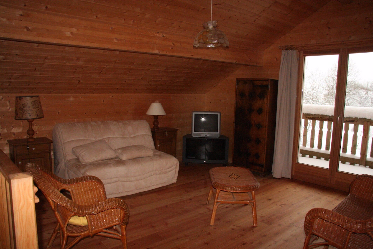 Wooden chalet interior with sofa and TV.