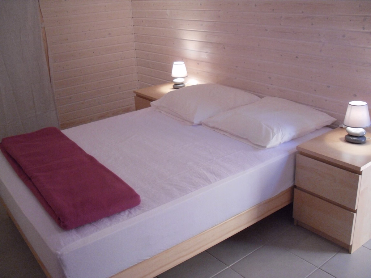 Eco Doublepng Simple wooden bedroom with double bed and lamps