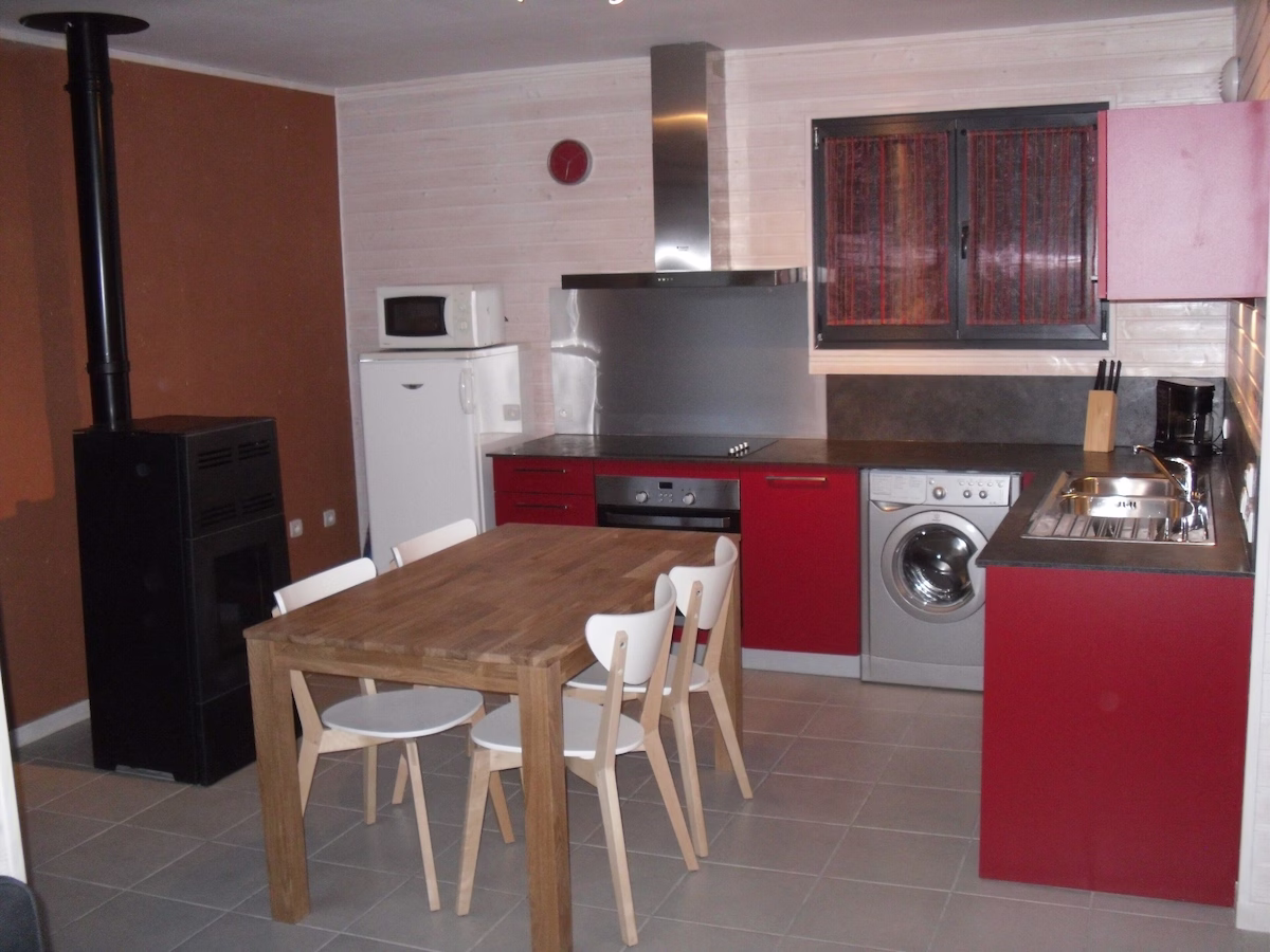 Eco Kitchen Modern kitchen with red cabinets and wood table.