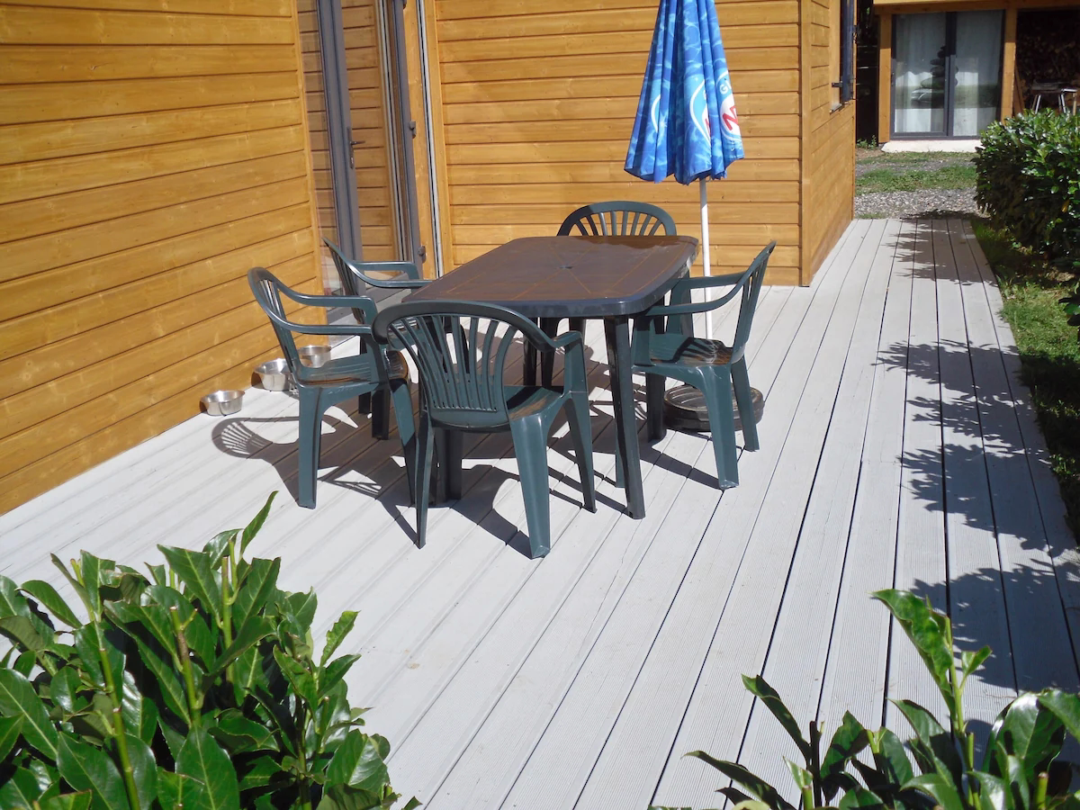 Eco outdoor decking Outdoor patio with table, chairs, and umbrella.