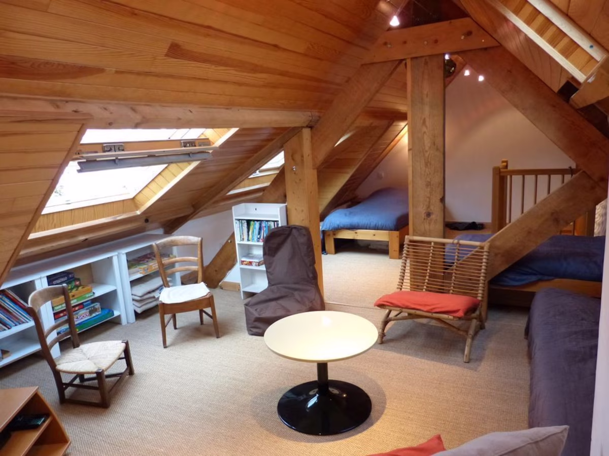 Cosy loft room with wooden beams and furniture.